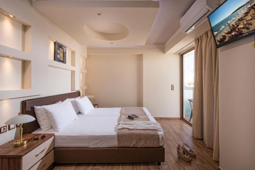 a bedroom with a bed and a large window at Harma Boutique Hotel in Hersonissos