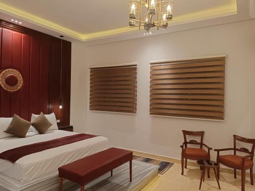a bedroom with a bed and two chairs and a chandelier at palm shadow resort in Tunis