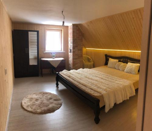 a bedroom with a large bed in a room at Будинок з лазнею in Mizhhirya