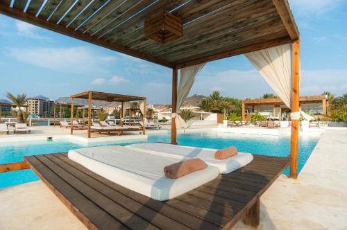 een groot bed naast een zwembad bij Mansa Marina Hotel in Mindelo