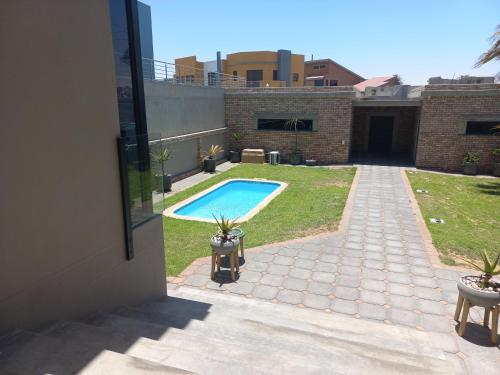 a view of a backyard with a swimming pool at Dolphin Beach Villa at 138 Oystercatcher, Swakopmund in Rand Rifles