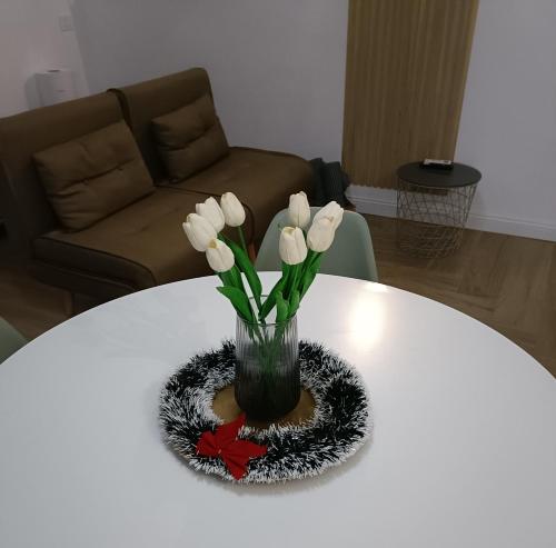a vase with white flowers on a white table at Dimora Isonzo in Siracusa
