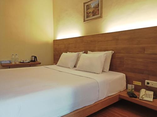 a bed in a hotel room with a telephone at Malino Highlands in Malino
