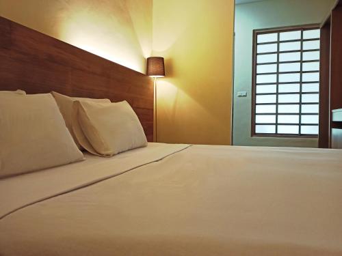 a bedroom with a large white bed with a window at Malino Highlands in Malino