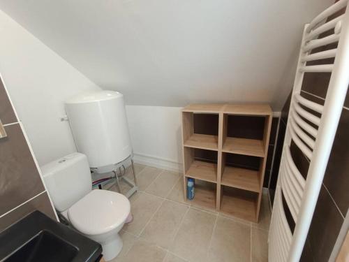 a small bathroom with a toilet and a shelf at La petite maison in Planchez