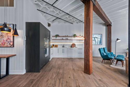 a kitchen with white cabinets and blue chairs in a room at Luxurious Woolstore Living! ~Teneriffe in Brisbane