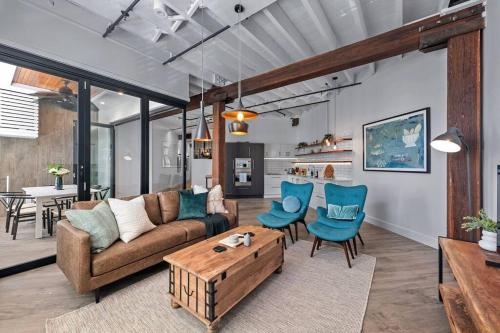 a living room with a couch and blue chairs at Luxurious Woolstore Living! ~Teneriffe in Brisbane