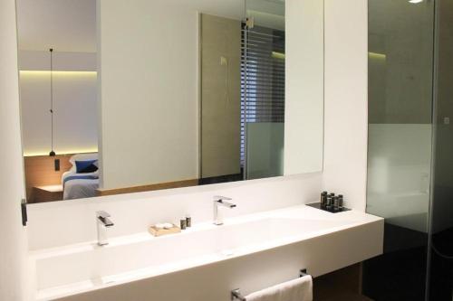 uma casa de banho com 2 lavatórios e um espelho grande em Athens Lodge by Athens Prime Hotels em Atenas
