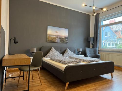 1 dormitorio con cama, mesa y escritorio en RB City Apartments Emden am Wall 2, en Emden