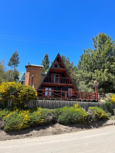 a large wooden house with a fence in front of it at El susurro in Villa Pehuenia