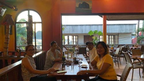 a group of people sitting at a table in a restaurant at Anang Balay Turista in El Nido