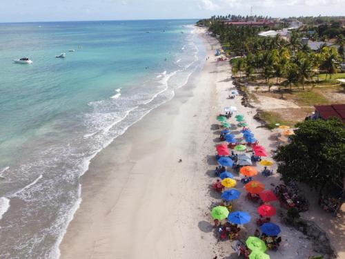 an overhead view of a beach with colorful umbrellas at Beira-mar Tamandaré / Carneiros in Tamandaré