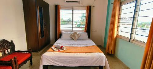 Un pequeño dormitorio con 2 camas y una silla roja en Cochin Hotel Inn, en Ernakulam
