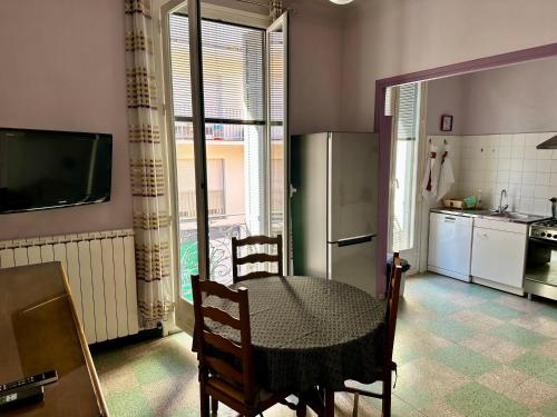 une cuisine avec une table et un réfrigérateur dans l'établissement APPARTEMENT N°1 LES CLEMATITES, à Menton