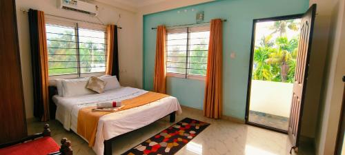 1 dormitorio con 1 cama y 2 ventanas grandes en Cochin Hotel Inn, en Ernakulam