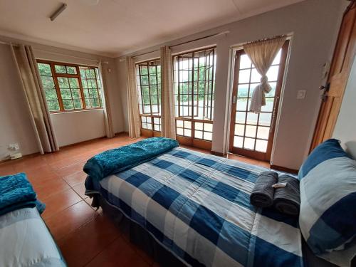 a bedroom with a bed with blue and white at Woodhills Guest house in Piet Retief