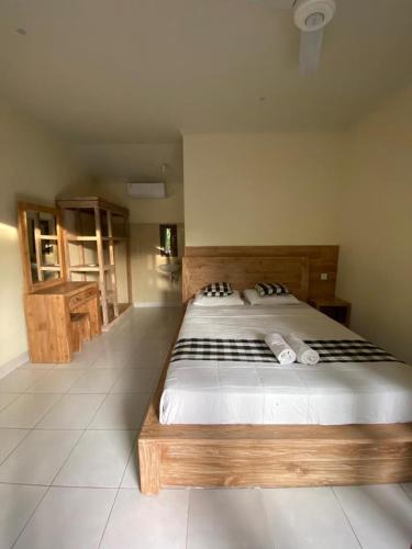 a bedroom with a large bed with black and white sheets at Nataliya Homestay in Ubud