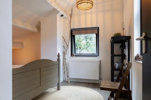 1 dormitorio con cama y ventana en Huusje21, en Nunspeet