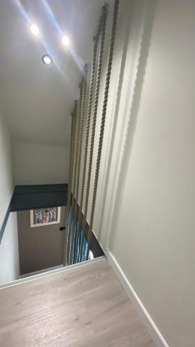 a hallway with a staircase with a stair railing at Le gîte des cràpauds rouges in Tréveneuc