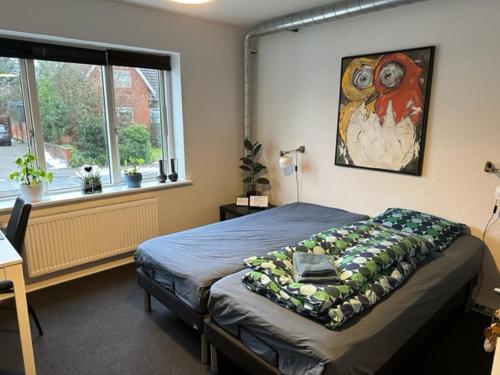 una camera da letto con un letto e un dipinto sul muro di Ikast Bed & Kitchen a Ikast