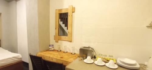 a kitchen with a table with a sink and a mirror at Yak City Apartments in Kandy