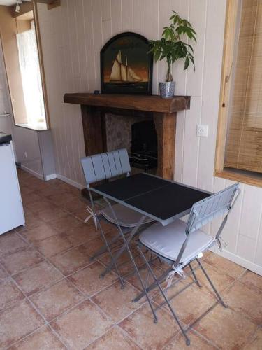 a table and two chairs in a room with a fireplace at La coco's house in Planchez
