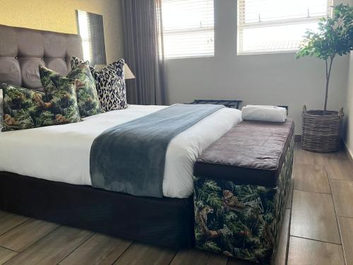 a bedroom with a large bed with a tufted headboard at 55 on Main Guesthouse and Spa in Fish hoek