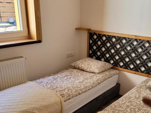 a small bedroom with a bed and a window at Leśna Kryjówka domki w lesie in Wersk