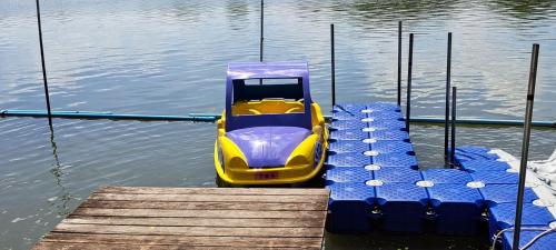 a yellow boat in the water next to a dock at Banbangei Riverside Poolvilla in Ban Bang Rathuk