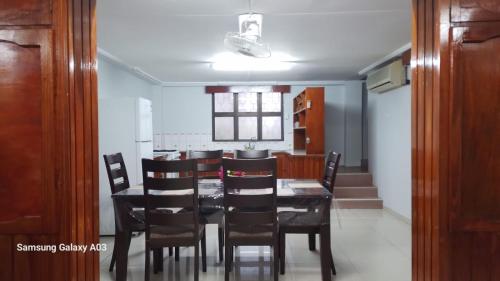 uma sala de jantar com uma mesa preta e cadeiras em NeemTree Villa- 5 Bedroom House On Its Own em Nadi