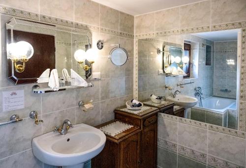 ein Badezimmer mit zwei Waschbecken, einem Spiegel und einer Badewanne in der Unterkunft Hotel No.16 in Bratislava
