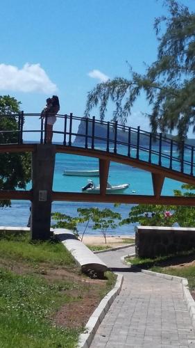 a person taking a picture of a person on a bridge at Spacieux appt 2ch 50m de la plage in Cap Malheureux