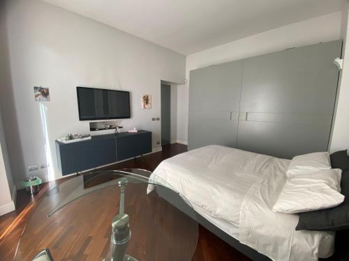 sypialnia z łóżkiem i telewizorem na ścianie w obiekcie A casa di Pele w Rzymie