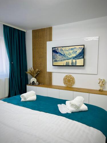 a bedroom with a bed with two pillows on it at MarbleHome~Straja/Lupeni in Lupeni