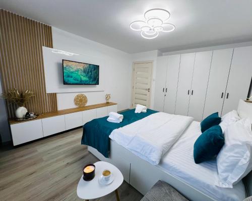 a bedroom with a large bed and a table at MarbleHome~Straja/Lupeni in Lupeni