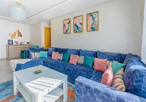 un sofá azul con almohadas coloridas en la sala de estar. en Urban Charm Delight, en Casablanca