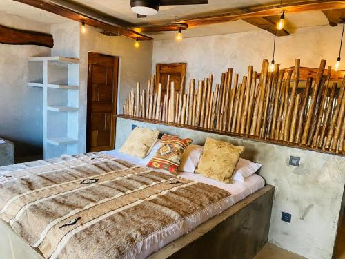 a bedroom with a bed and a bunch of wooden sticks at CAJOU LODGE in Bubaque