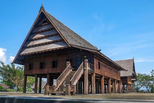 un gran edificio de madera con un techo empinado en SAPO SAPO, en Karema