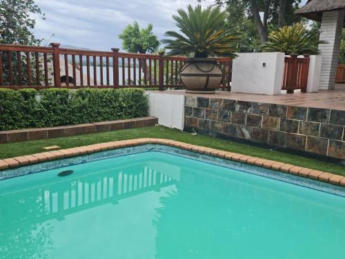 a swimming pool in a yard with a wooden fence at 147@ Simon Bekker Kosmos in Hartbeespoort