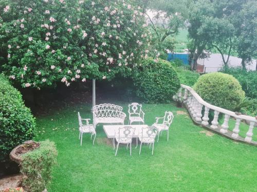 a table and chairs in a yard with a tree at 147@ Simon Bekker Kosmos in Hartbeespoort