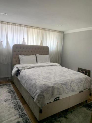 a bedroom with a large bed with white sheets at Vita Suit in Küçükköy