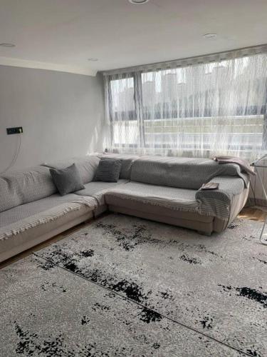 a living room with a couch in front of a window at Vita Suit in Küçükköy