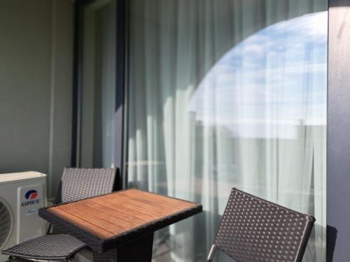 y balcón con mesa y sillas de madera. en LUXURY APARTMENT in Mediterranea VARNA Complex, sea view and Infinity pool, en Varna