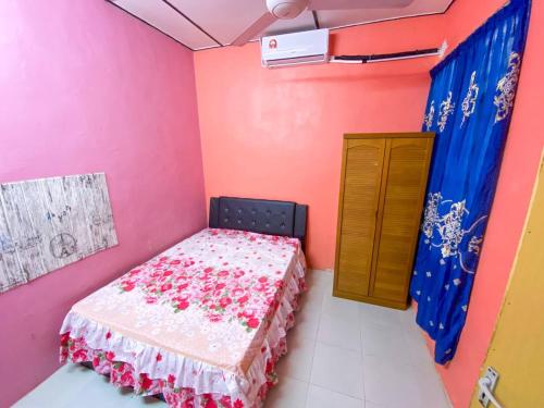 ein Schlafzimmer mit einem Bett in einem Zimmer mit rosa Wänden in der Unterkunft D'JERAI HOMESTAY in Guar Chempedak