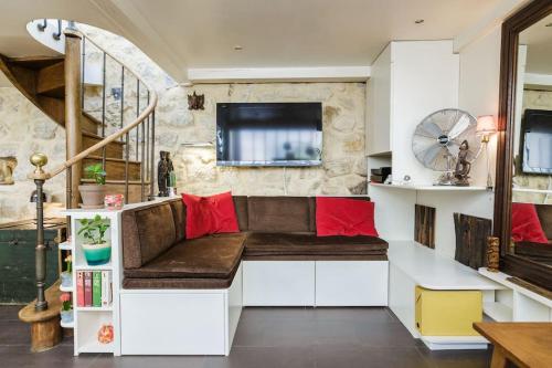 - un salon avec un banc et une télévision dans l'établissement Peace and greenery, heart of Paris, à Paris