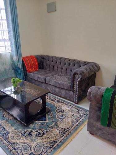 a living room with a couch and a coffee table at Apartment next to Cravers, Thika in Thika