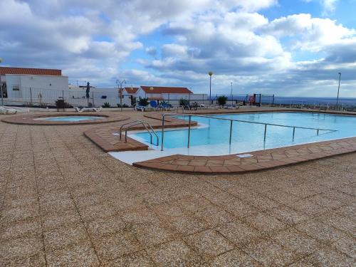 una piscina de agua con un parque infantil en un edificio en Casa Yanira, en Caleta de Fuste