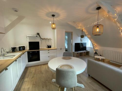 a kitchen and living room with a table and a counter at Appartement en centre ville de Gourin in Gourin
