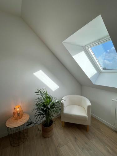 een kamer met een witte stoel en een raam bij Appartement en centre ville de Gourin in Gourin