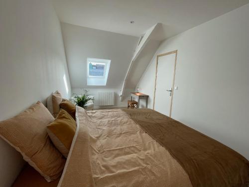 a bedroom with a large bed in an attic at Appartement en centre ville de Gourin in Gourin